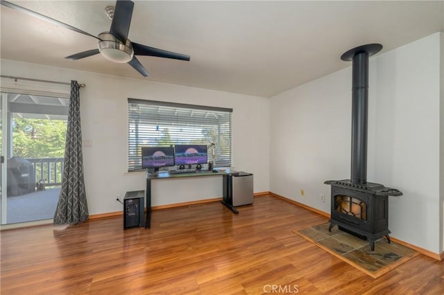 living room with a wood stove, light hardwood / wood-style flooring, and a healthy amount of sunlight