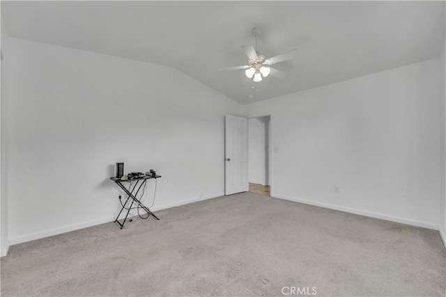 carpeted spare room featuring ceiling fan and vaulted ceiling