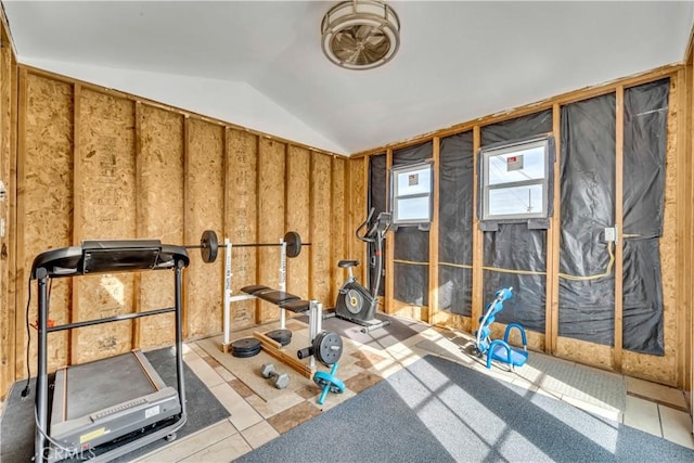 workout room with light tile patterned flooring and vaulted ceiling