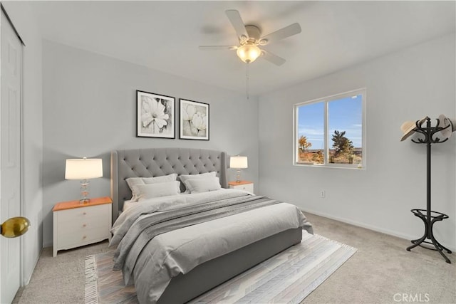 bedroom featuring ceiling fan, light colored carpet, and a closet