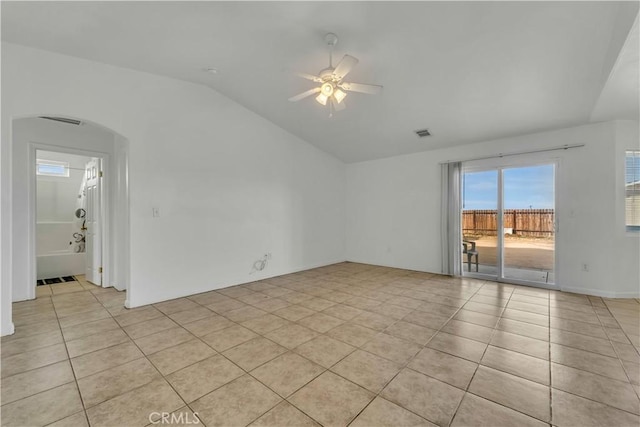 tiled empty room with ceiling fan and vaulted ceiling