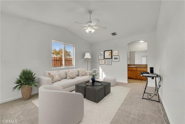 living room featuring ceiling fan, light colored carpet, and lofted ceiling