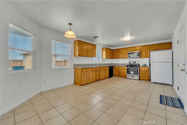 kitchen with pendant lighting, light tile patterned flooring, sink, and appliances with stainless steel finishes