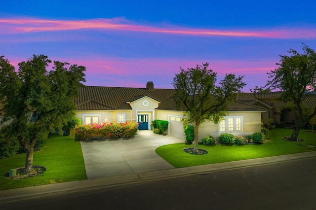 view of front of home with a lawn and a garage