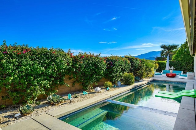 view of swimming pool featuring a patio area, a mountain view, and an in ground hot tub