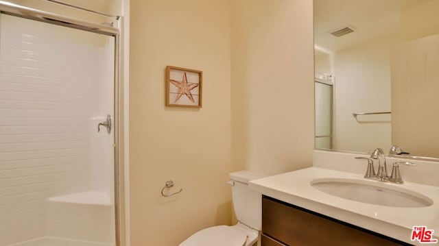 bathroom with vanity, toilet, and walk in shower