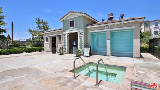 back of property with a patio area and a hot tub