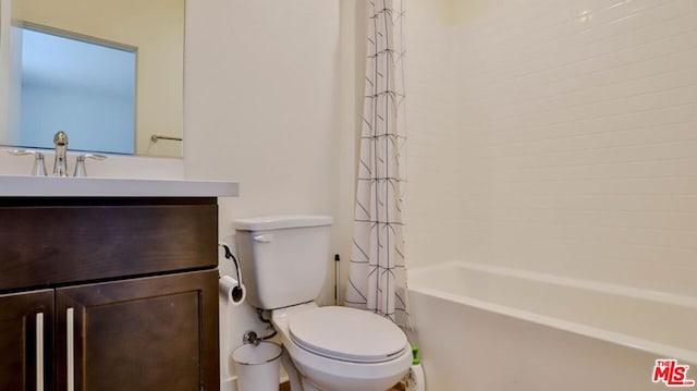 full bathroom featuring shower / bath combo with shower curtain, vanity, and toilet