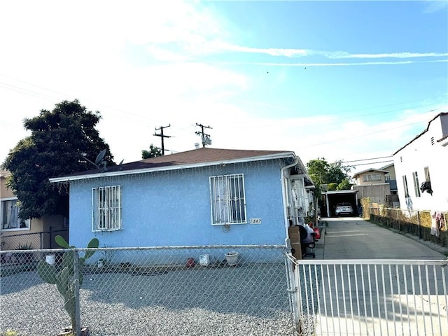 view of front of house with a fenced front yard, stucco siding, and driveway