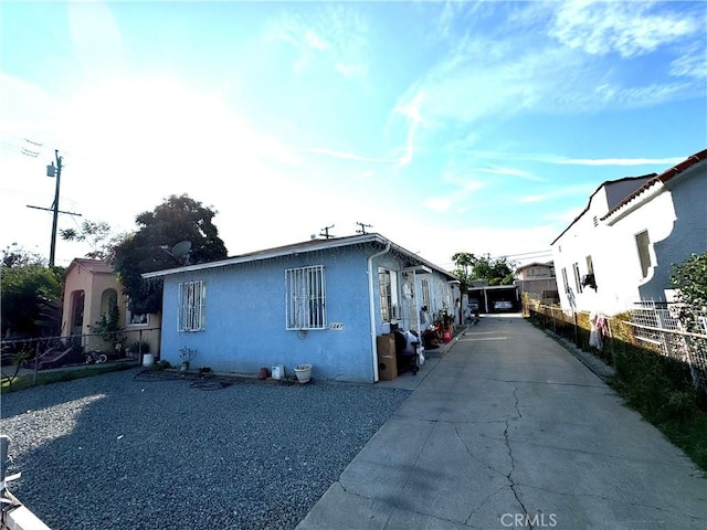 view of front of home with stucco siding and fence