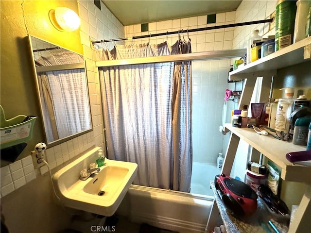 bathroom with sink, shower / bath combo with shower curtain, tile walls, and tasteful backsplash