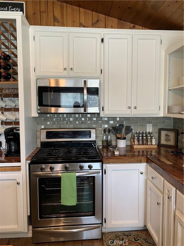 kitchen featuring tasteful backsplash, white cabinets, stainless steel appliances, and lofted ceiling