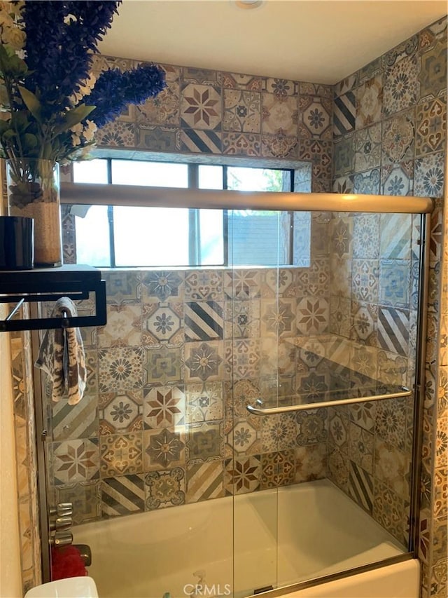 bathroom featuring shower / bath combination with glass door