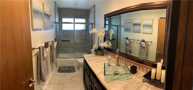 full bathroom featuring tile patterned floors, shower / bath combination with glass door, vanity, and toilet