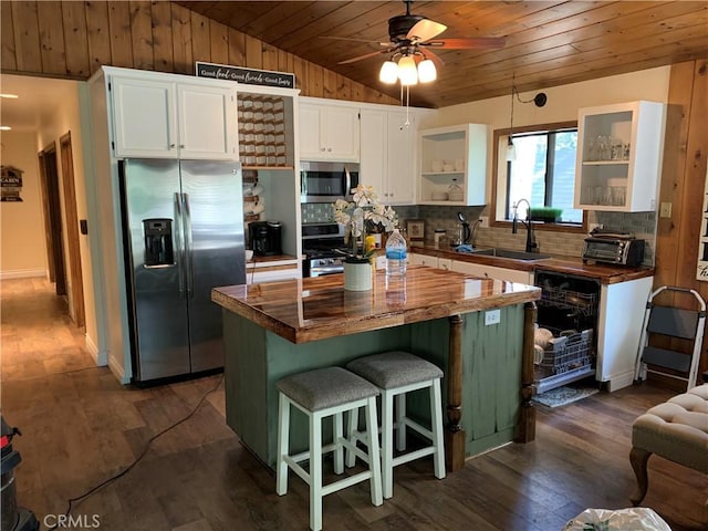 kitchen with wood counters, appliances with stainless steel finishes, white cabinetry, and sink