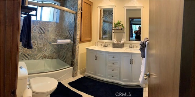 full bathroom featuring tile patterned floors, bath / shower combo with glass door, toilet, and vanity