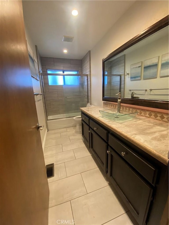 full bathroom with shower / bath combination with glass door, vanity, toilet, and tile patterned flooring