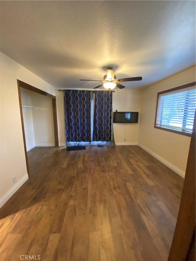 interior space with ceiling fan, dark wood-type flooring, and a textured ceiling