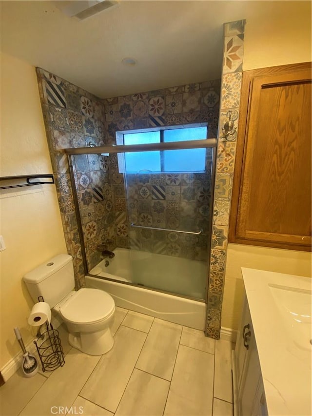 full bathroom with combined bath / shower with glass door, vanity, tile patterned flooring, and toilet