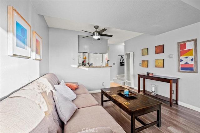 living room featuring ceiling fan and wood-type flooring