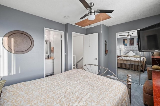 bedroom featuring ensuite bath, ceiling fan, a textured ceiling, a closet, and carpet