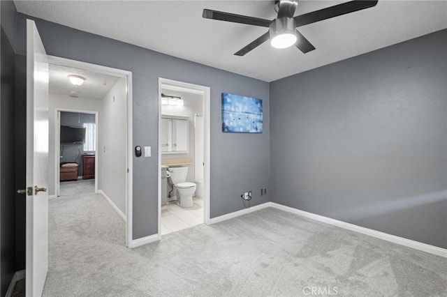 unfurnished bedroom featuring light carpet, ensuite bath, and ceiling fan