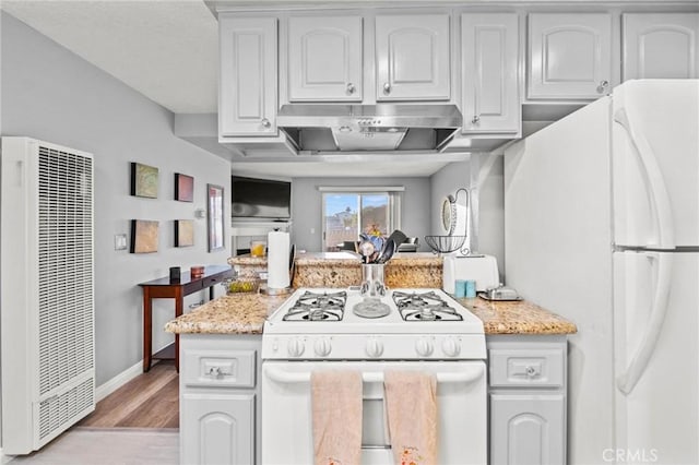 kitchen featuring light stone counters, light hardwood / wood-style flooring, range hood, white appliances, and white cabinets