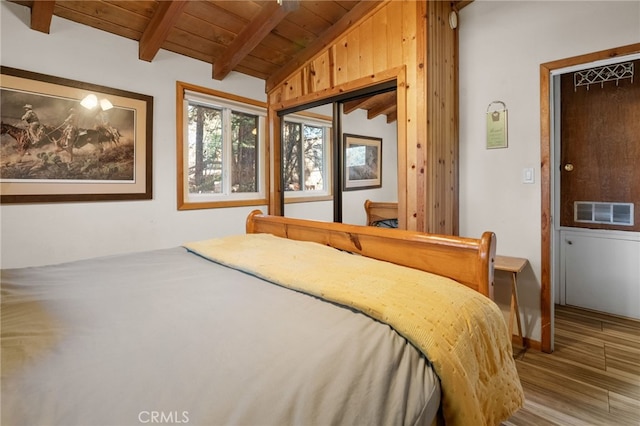 bedroom with wooden ceiling, visible vents, lofted ceiling with beams, and wood finished floors