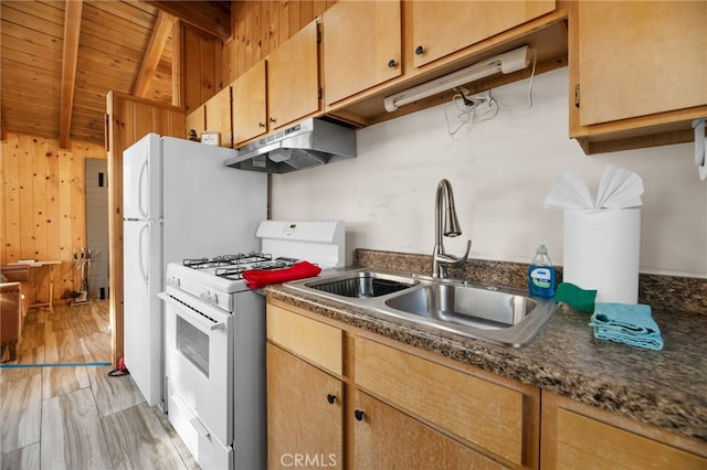 kitchen with white gas range, dark countertops, a sink, beamed ceiling, and under cabinet range hood