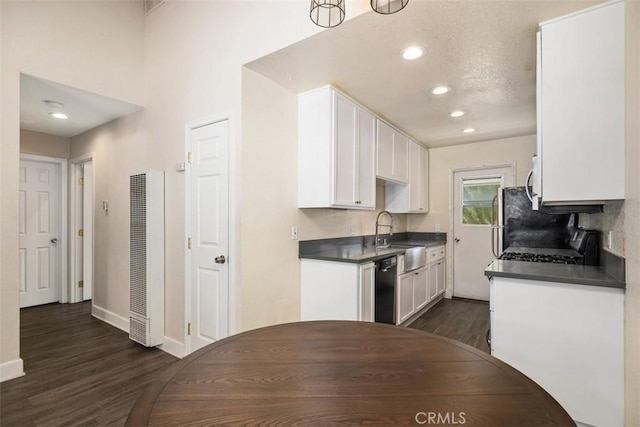 kitchen featuring dishwasher, dark countertops, a sink, and white cabinets