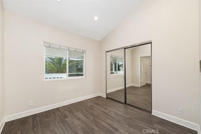 unfurnished bedroom with lofted ceiling, a closet, recessed lighting, dark wood-type flooring, and baseboards