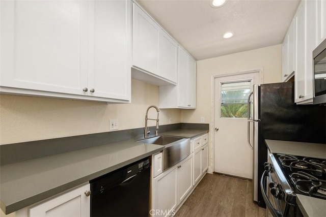 kitchen featuring dark wood-style floors, black dishwasher, white cabinetry, and a sink