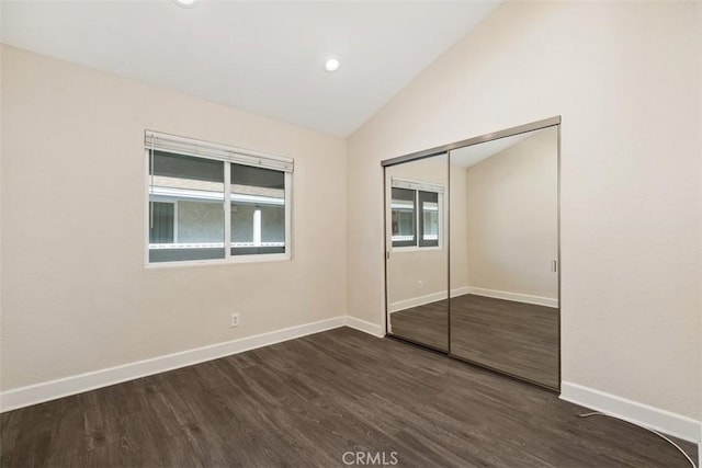 unfurnished bedroom featuring lofted ceiling, a closet, recessed lighting, dark wood-type flooring, and baseboards