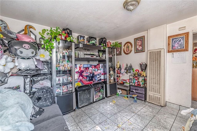 playroom with a textured ceiling and light tile patterned flooring