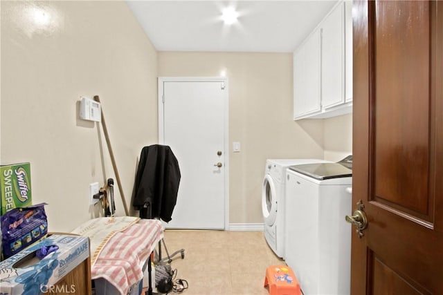 laundry area featuring washer and clothes dryer and cabinets