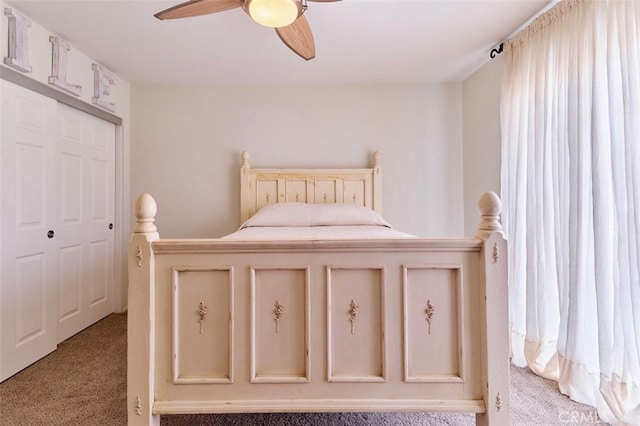 carpeted bedroom with ceiling fan and a closet