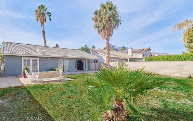 back of property featuring a yard, a patio area, and french doors