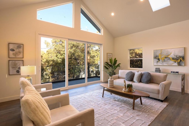 living room with hardwood / wood-style flooring, a healthy amount of sunlight, high vaulted ceiling, and a skylight