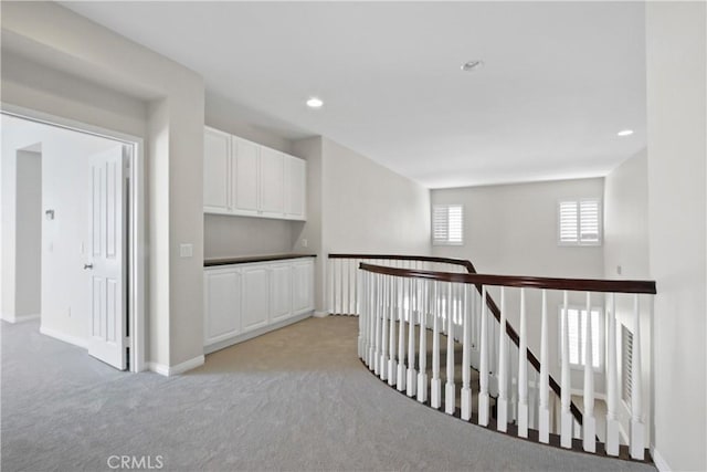 hallway with light colored carpet