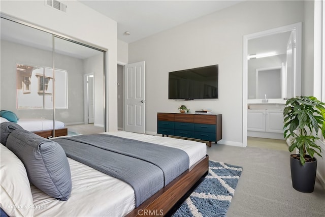 carpeted bedroom featuring ensuite bath and a closet