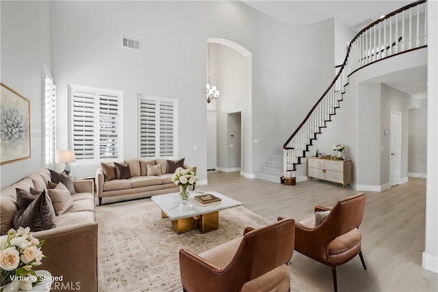 living room featuring a high ceiling and light wood-type flooring