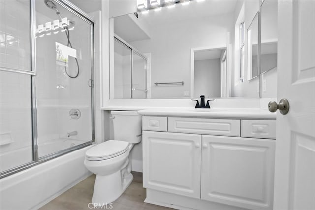 full bathroom with vanity, toilet, and bath / shower combo with glass door