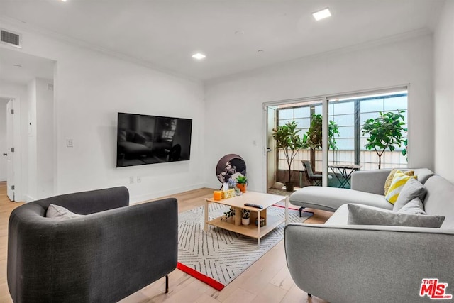 living room featuring light hardwood / wood-style floors and ornamental molding