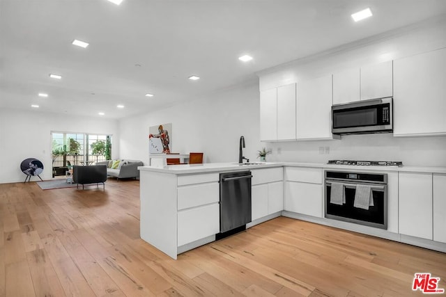 kitchen featuring white cabinets, kitchen peninsula, appliances with stainless steel finishes, and light hardwood / wood-style flooring