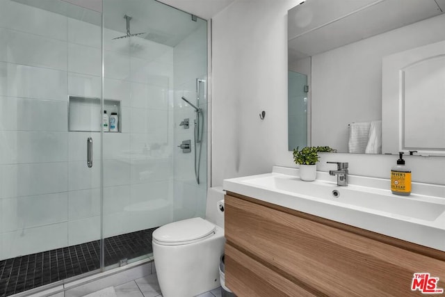 bathroom featuring vanity, a shower with shower door, and toilet