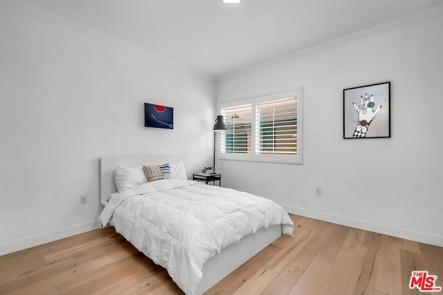 bedroom with hardwood / wood-style floors and crown molding