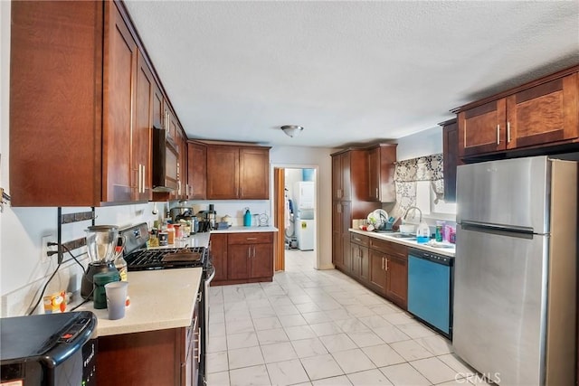 kitchen with a textured ceiling, sink, and stainless steel appliances