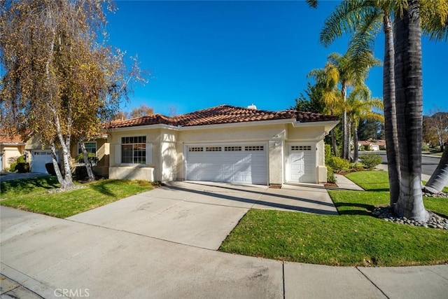 mediterranean / spanish-style home with a front yard and a garage