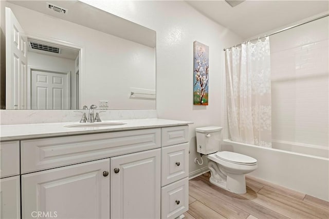 full bathroom with vanity, wood-type flooring, shower / bath combo, and toilet