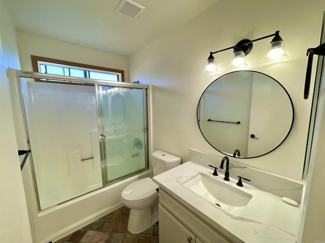 full bathroom featuring shower / bath combination with glass door, vanity, and toilet